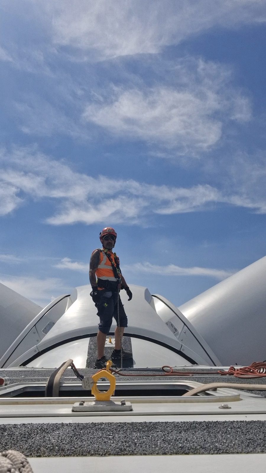 Industriekletterer auf dem Dach der Gondel einer Windkraftanlage im Schwarzwald