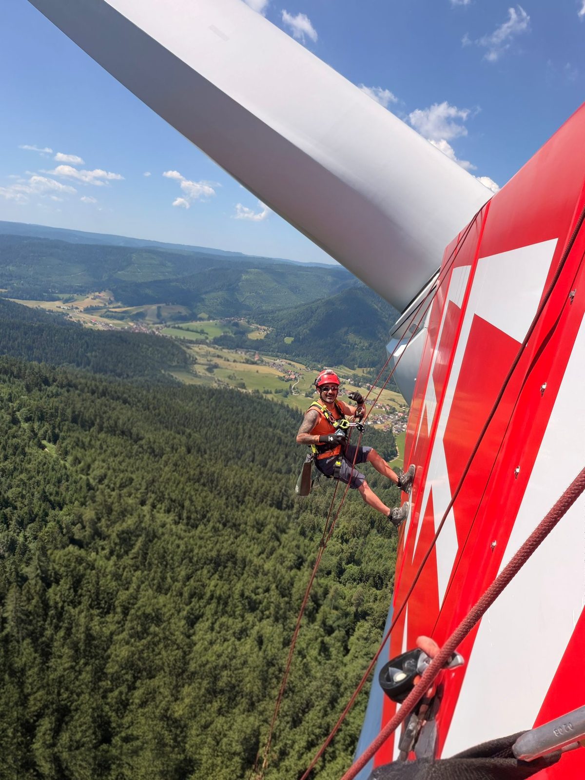 Industriekletterer beim Abseilen an einer Windkraftanlage über dem Schwarzwald